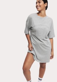 Grå oversized t-shirt klänning med korta ärmar och rundad halsringning, med präglad text "DAYDREAMER". Mjuk tyg, avslappnad design.