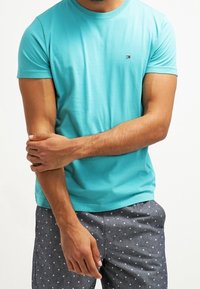 Turquoise short-sleeve t-shirt made of cotton. Features a small logo on the chest, with a plain design and standard fit.