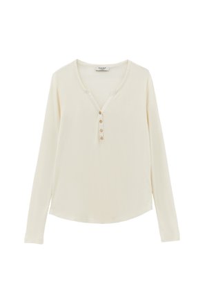 Cremefarbener Langarmpullover mit V-Ausschnitt und fünf Knöpfen vorne. Weicher Stoff mit lockerer Passform und abgerundetem Saum.