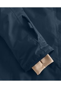 Marine windbreaker met een gladde textuur, voorzien van een beige elastische manchet en een verborgen zak op de mouw voor praktisch gebruik.