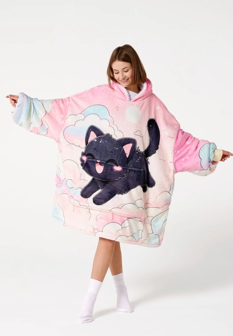 Overmaat hoodie-deken van zachte fleece. Roze achtergrond met wolkpatronen en een zwarte kat in een speelse pose.
