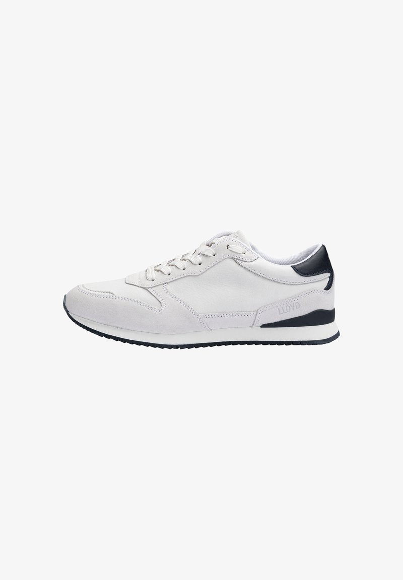Zapatilla de ante gris claro con detalles en negro, diseño con cordones, puntera redonda y suela texturizada. Presenta una marca sutil en el lateral.
