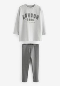 Vaaleanharmaa collegepaita, jossa on "LONDON 1996" -grafiikka; yhdistetty tummanharmaisiin ribbileggingseihin. Molemmat ovat pehmeitä, rennon tyyppisiä vaatteita mukavuutta varten.