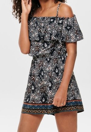 Czarny kombinezon na ramiączkach z wzorem paisley, falbaniaste wykończenie u góry, elastyczny pas i wzorzysty brzeg. Wykonany z lekkiego materiału.