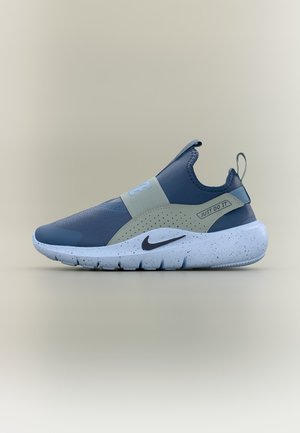 Σκούρο μπλε και γκρι αθλητικό παπούτσι Nike χωρίς κορδόνια με λευκή σόλα με στίγματα, μαύρο σήμα swoosh και το κείμενο "Just Do It" στο πλαϊνό λουράκι.