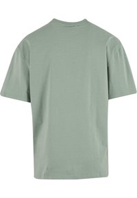 Green cotton t-shirt with short sleeves, round neckline, and a relaxed fit. Smooth texture, no visible patterns or graphics.
