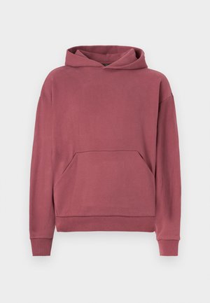 Prašná ružová mikina s kapucňou a klokankou, s rebrovanými manžetami a lemovaním, vystavená na bielom pozadí.