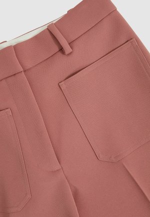 Roze geribde broek met een gestructureerde afwerking, voorzien van twee grote achterzakken en een platte tailleband aan de voorkant.
