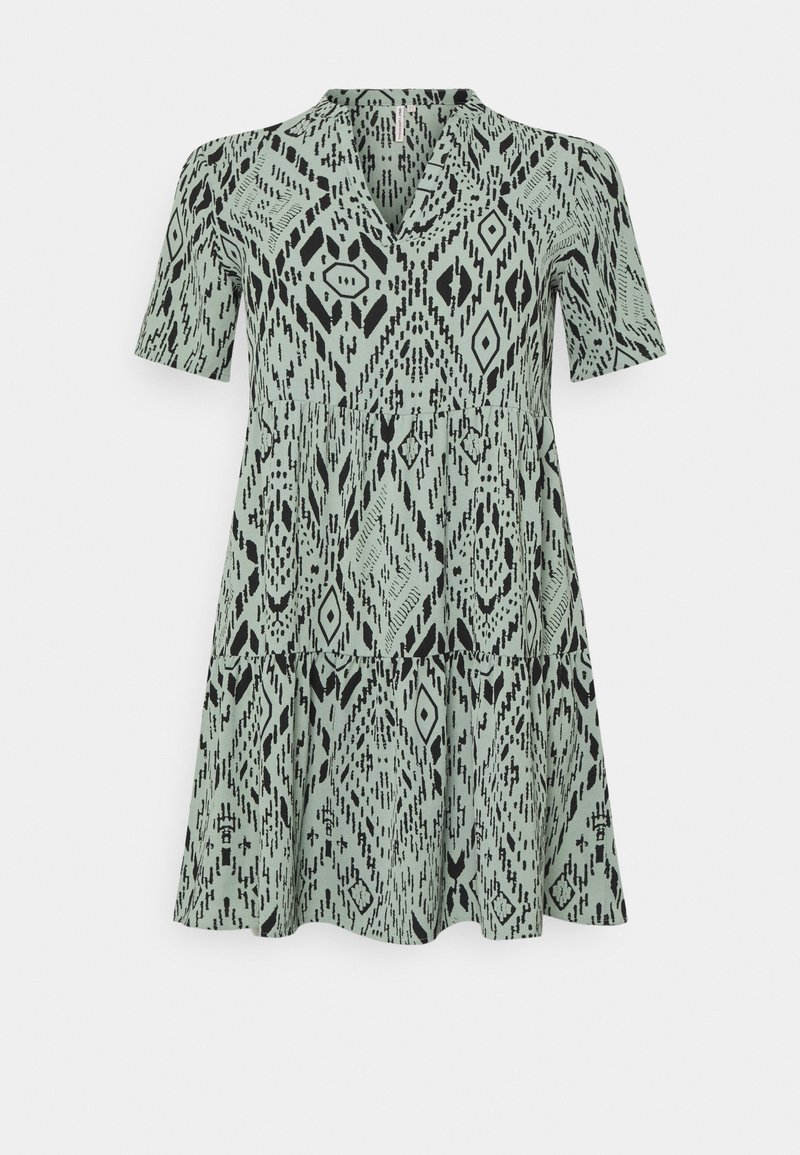 Šaty s krátkým rukávem ve světle zeleném odstínu se vzorem černých geometrických tvarů s diamanty a čarami, výstřih do V a rozšířený lem.