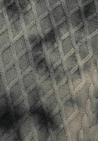Strickstoff mit einem Rautenmuster in verschiedenen Grautönen, mit einer strukturierten, weichen Oberfläche und klaren Nähten.