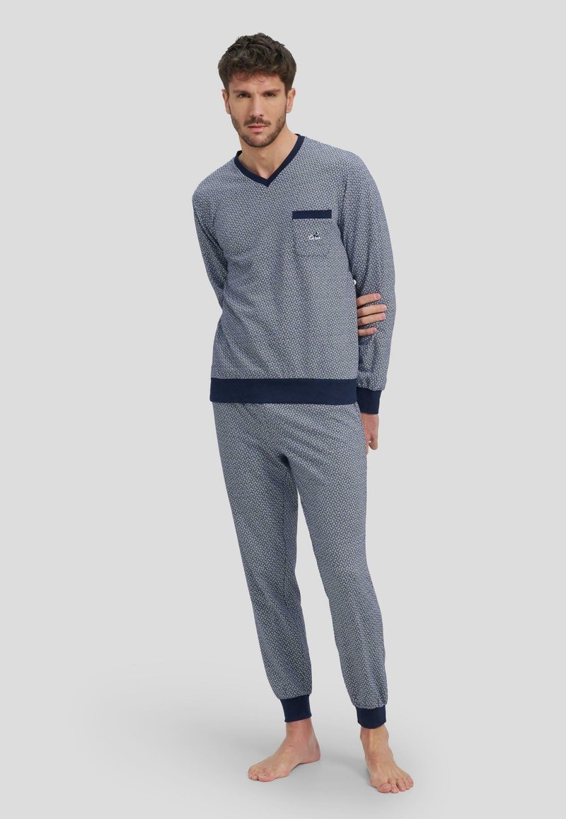 Conjunto de loungewear de rayas en azul marino y blanco con mangas largas y pantalones a juego. Presenta un escote en V y detalle de bolsillo en la camiseta.
