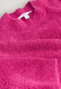 Sød pink sweater med rund hals, der har en blød tekstur og en diskret glans. Mærket siger "NEXT".