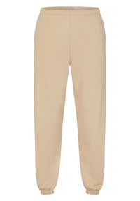 Beżowe dresy wykonane z miękkiego materiału, z elastycznym pasem i ściągaczami przy kostkach. Prosty krój nogawek.