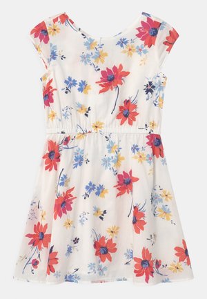 Robe blanche à manches courtes avec une taille froncée, présentant un motif floral de fleurs rouges, bleues et jaunes.