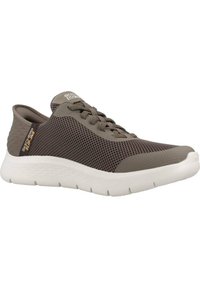 Zapatilla de malla marrón con una suela ligera blanca, presenta un cierre de cordones y sutiles acentos texturizados. Marca visible en el lateral.