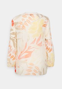 Kwiatowa bluzka z jasnego, przezroczystego materiału, na którym znajdują się duże żółte, pomarańczowe i beżowe wzory liści; balonowe rękawy i okrągły dekolt.