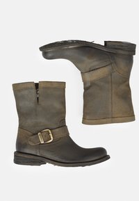 Botas de piel marrón hasta el tobillo con una correa con hebilla, que cuentan con un acabado texturizado, tacón bajo apilado y cierre de cremallera lateral para ponérselas fácilmente.