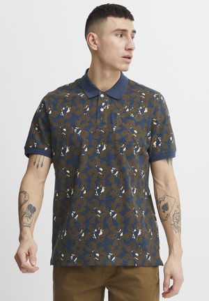 Kortærmet polo-shirt i marineblå og brun, med et blomsterdesign, ensfarvet marineblå krave og tre knapper. Lavet af bomuldsstof, afslappet pasform.