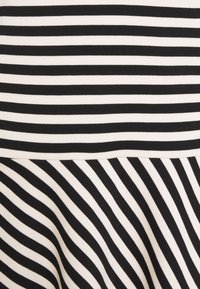 Svart och vit randig tyg med varierande randbredder, med en slät yta. Ränderna är horisontella och kontinuerliga.