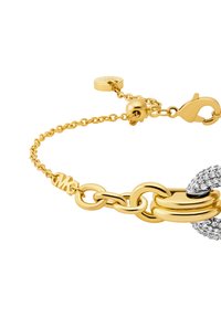 Kultainen rannekoru, jossa on toisiinsa kytkeytyviä linkkejä, lukko ja osa, joka on koristeltu kirkkailla rhinestoneilla lisäyksityiskohtia varten.