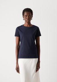 T-shirt in cotone blu navy con collo rotondo classico e maniche corte, caratterizzato da un ricamo del logo discreto sul petto. Texture liscia.