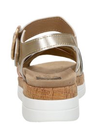 Goldene Falsalleder-Sandalette mit Korkwedge-Absatz, weißer Laufsohle, verstellbarem Riemen mit einer großen runden Schnalle und softem beigen Fußbett.