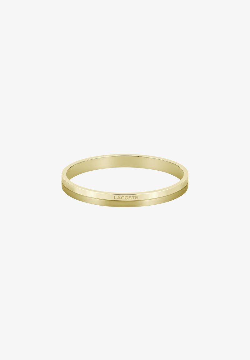 Arany bangle karkötő sima, fényes felülettel. Diszkrét Lacoste gravírozással rendelkezik, egyszerű, elegáns formája és kerek alakja van.