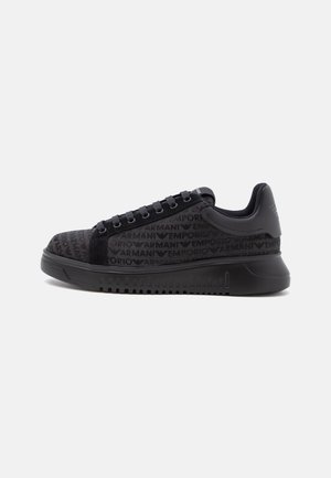 Μαύρο χαμηλό sneaker με ανάγλυφο μοτίβο λογότυπου Emporio Armani, μαύρα κορδόνια και παχιά σόλα, εμφανίζεται σε προβολή από δεξιά πλευρά.