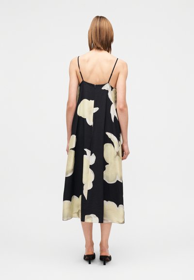Μαύρο μεσοφόρεμα με λουλούδια και λεπτές τιράντες, με μεγάλα αφηρημένα λουλούδια σε κρεμ απόχρωση, ρέον ύφασμα και άνετη γραμμή.
