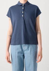 Polo bleu marine en coton, avec un col, des manches courtes et cinq boutons blancs sur le devant.