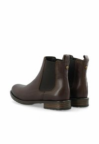 Stivaletti alla caviglia in pelle marrone con pannelli laterali elastici, punta arrotondata e tacco impilato. Presentano cuciture minime e bottoni decorativi discreti.