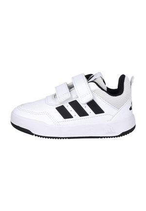 Zapatilla deportiva blanca con dos correas de velcro, diseño de tres rayas negras en el lateral y forro interior acolchado negro.