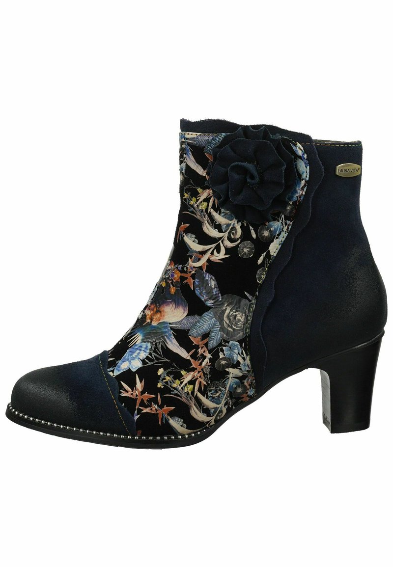 Stivaletto navy con dettaglio di tessuto floreale, bordi ondulati, accentuazione in tessuto a forma di fiore e tacco medio. Decorazione con perline lungo la suola.