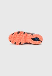 Baskets de course noires avec une semelle extérieure orange texturée, présentant des crampons de traction noirs et deux accents circulaires bleus près du talon.