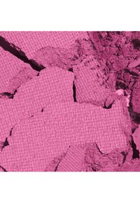 Poudre de maquillage rose écrasée avec une texture, morceaux cassés et poudre fine dispersée sur une surface plane.