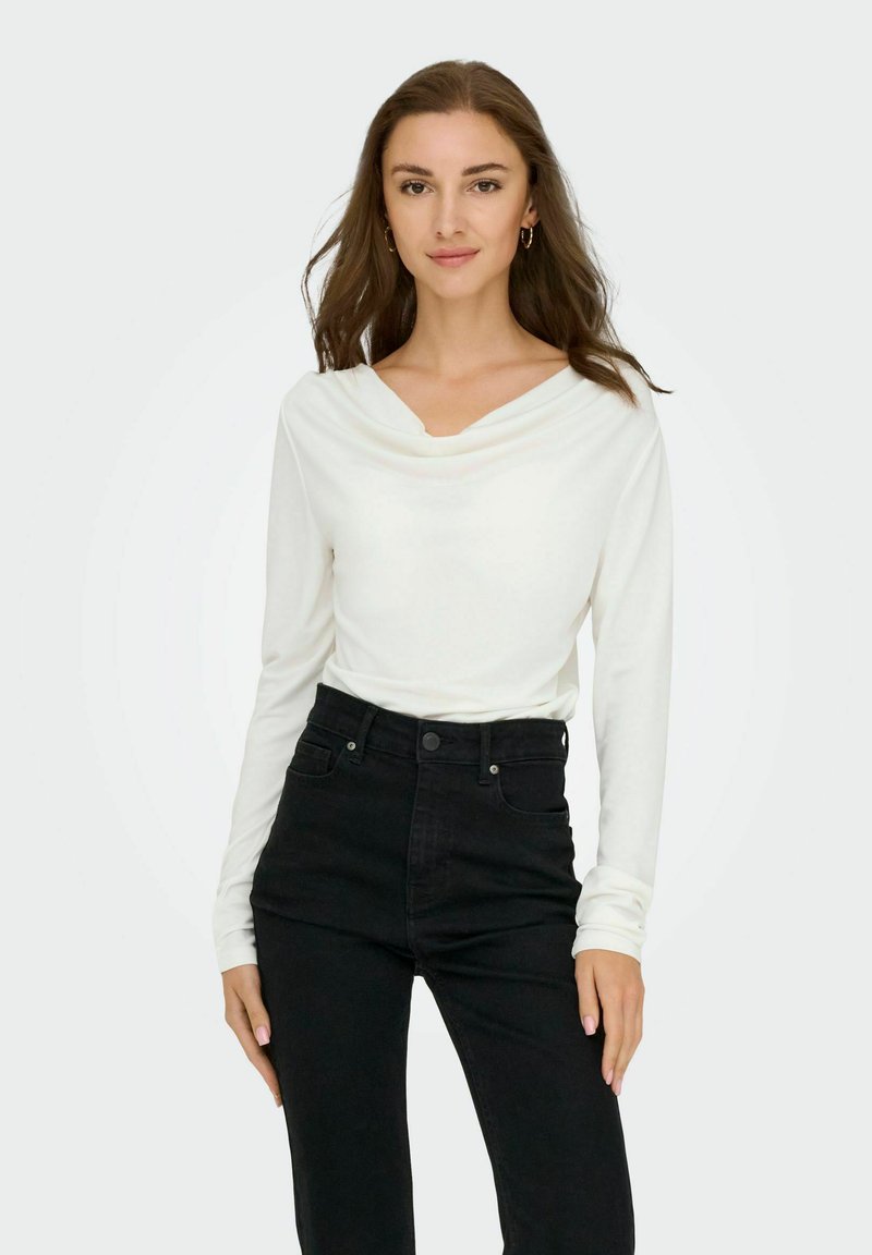Witte long-sleeve top met een kraaglijn, gecombineerd met high-waisted zwarte jeans. Glad ontwerp, nauwsluitende pasvorm en minimale details.