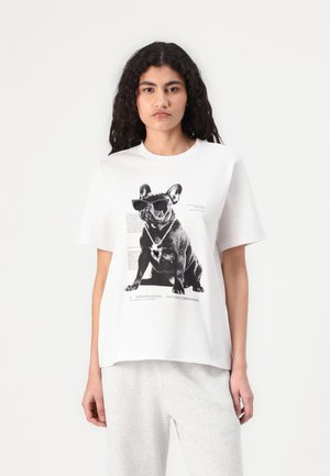 White cotton t-shirt features a graphic of a French Bulldog wearing sunglasses, with text and design elements printed around it.