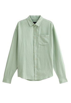 Camisa de manga larga verde claro hecha de un tejido suave y texturizado. Presenta un cierre de botones en la parte delantera, un collar puntiagudo y un bolsillo en el pecho.