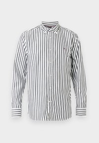 Πουκάμισο με ρίγες σε μαύρο και άσπρο, με γιακά κουμπωτό, μακριά μανίκια και μικρό λογότυπο στο στήθος. Διαθέτει μανσέτες με αντίθετες ρίγες.