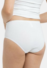Weiße Baumwollunterwäsche mit hoher Taille, glatter Textur, einfachem Design und weichem elastischem Bund, von der Seite und rückseitig gezeigt.