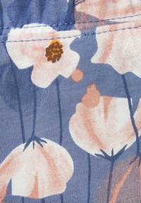 Blumiger Stoff mit großen weißen und pfirsichfarbenen Blumen auf blauem Hintergrund. Leichtes, strukturiertes Material mit gerippter Oberfläche.