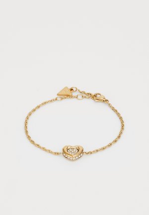 Gullfarget armbånd med et vridd kjededesign, som har et hjerteformet charm prydet med klare krystaller og en klipslås.