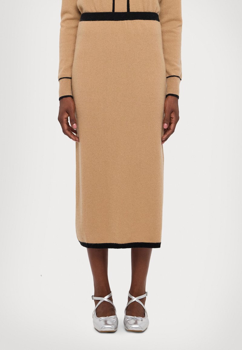 Knit wool skirt in light beige with a black waistband and hem. Features a straight silhouette, smooth texture, and knee-length design.