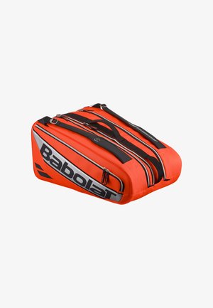 Orange tennis taske med sorte accenter, der har flere lynlåse og et stort "Babolat" logo på siden. Glat tekstur, polstrede stropper.