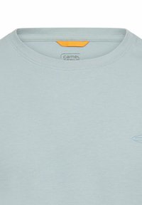 Hellblaues kurzärmeliges T-Shirt mit Rundhalsausschnitt, aus weichem Stoff; mit kleinem Logo und einem orangefarbenen Etikett am Nacken.