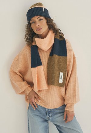 Pfirsichfarbener gerippter Pullover mit weiten Ärmeln, navy- und khaki-farbenem gemustertem Schal und passender Mütze. Weiche Texturen mit einem gemütlichen Design.