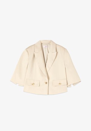Blazer beige court avec larges revers, manches trois-quarts, deux poches à rabat à l'avant avec boutons dorés, et une fermeture à un seul bouton doré.