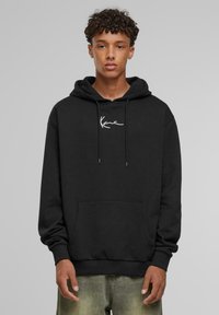Felpa nera con tasca frontale, cappuccio con cordino e logo bianco sul petto. Materiale morbido con maniche e orlo a coste.