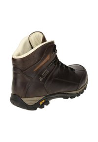 Botte de randonnée en cuir marron avec une doublure intérieure blanche, des lacets noirs et une semelle en caoutchouc texturée ; présente un logo Vibram sur la semelle extérieure.