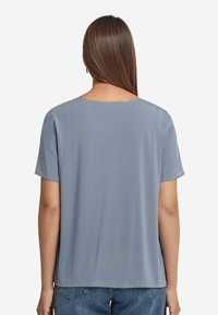 Ljusblå kortärmad t-shirt med rund halsringning, tillverkad av mjukt tyg, med en avslappnad passform och rak nederkant.